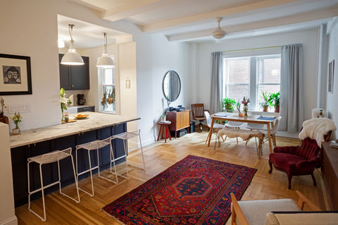 Open kitchen and living room with dining area and red rug