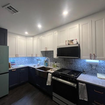 Modern kitchen with white and navy cabinets, light blue refrigerator