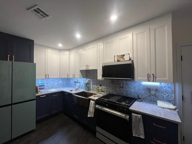Renovated prewar co-op with bold navy kitchen, exposed brick accent wall, and sliding barn door at 353 Ocean Avenue, Apt 6E, Prospect Lefferts Gardens, Brooklyn
