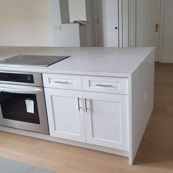 Modern kitchen island with white cabinets and built-in oven