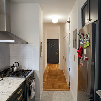 Remodeled kitchen with stove, marble counter, and refrigerator