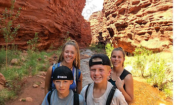 4 teens hiking through Professor Creek canyon Moab Utah