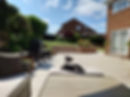 A dog looking at gorgeous, newly paved garden with tiered steps to a large turfed area