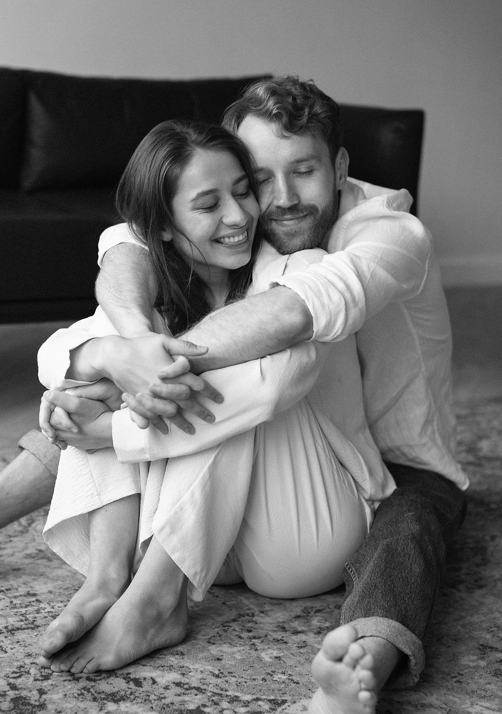 full-shot-smiley-couple-sitting-floor.jpg