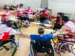 Jugadores del equipo de baloncesto en silla de ruedas BSR Cantabria, reunidos en círculo antes de empezar el partido.