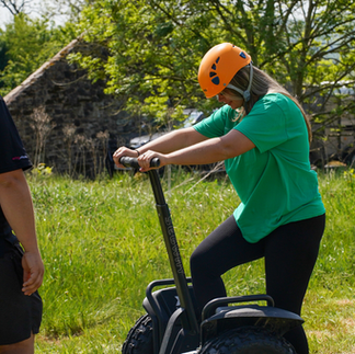 Team member in a green t-shirt climbing onto a segway.