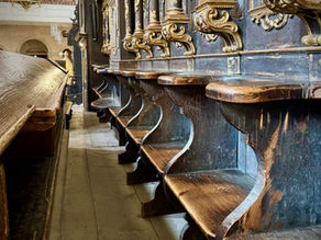 Detail eines barocken Chorgestühls mit klappbaren Holzsitzen im Gurker Dom