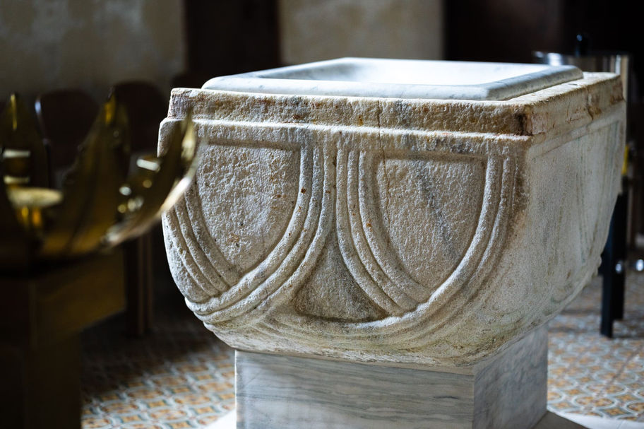 Nahaufnahme des romanischen Taufsteins in der Stadtpfarrkirche St. Bartholomäus in Friesach.