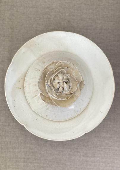 Floral themed cloche dish presented on a flanged plate