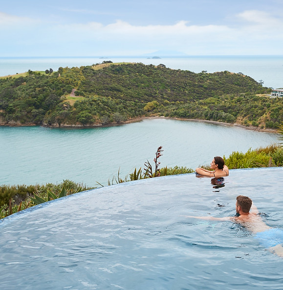 Gasten in het zwembad van Delamore Lodge op Waiheke Island tijdens een luxe verblijf in Nieuw-Zeeland