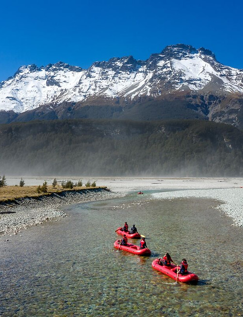 Dart River Funyaks in de regio Glenorchy, Nieuw-Zeeland, met kajaks op helder water omringd door ruige bergen met besneeuwde toppen, als onderdeel van een actieve maar toegankelijke rondreis.