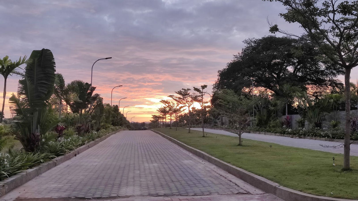 : "Charming pathways winding through the lush greenery of Rhythms of Earth, a prime example of Tula Properties' agricultural land for sale in strategic locations."