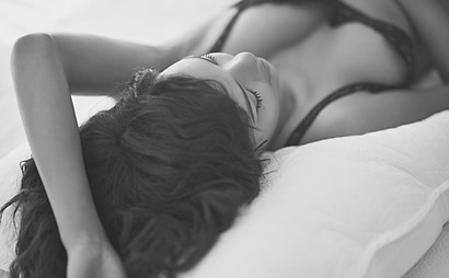 Mulher jovem deitado na cama desgasta a roupa interior