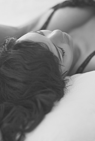Young Woman Lying in Bed Wearing Lingerie