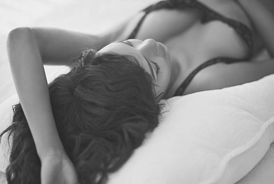 Young Woman Lying in Bed Wearing Lingerie