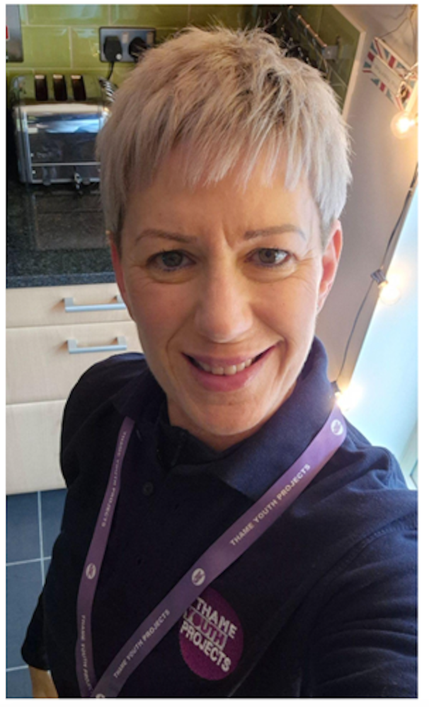 Michelle smiling for a selfie wearing a Thame Youth Projects polo shirt and lanyard