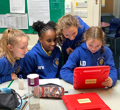 Girls looking at an iPad in a video game design workshop