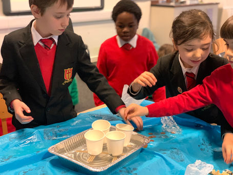 Children making a boat out of paper cups for a stem workshop