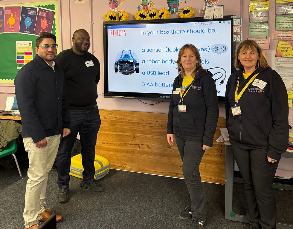 four people standing in front of a whiteboard for an engineering workshop in primary school
