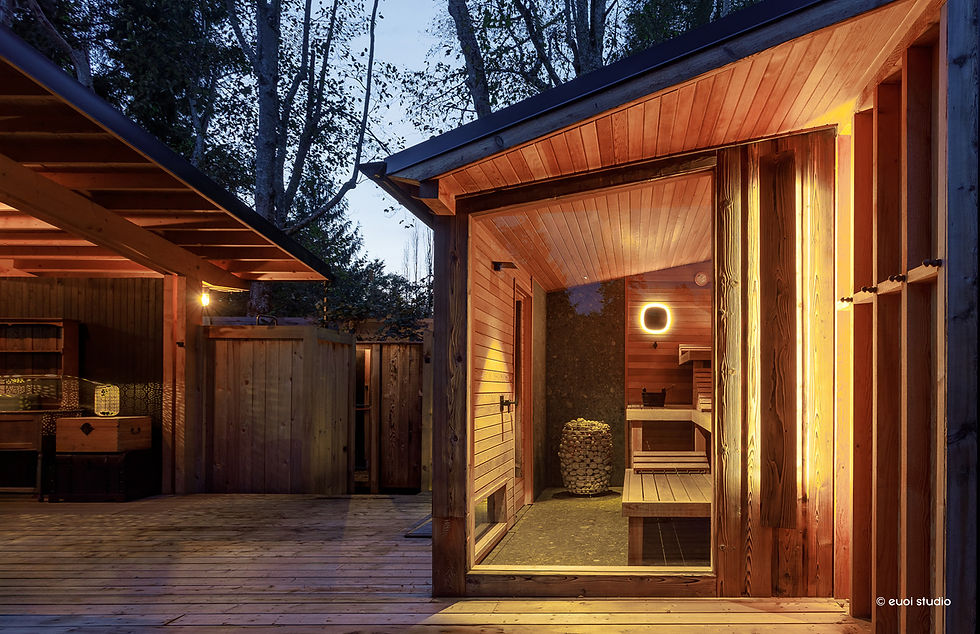 Cedar-clad sauna with warm interior lighting and large glass window, nestled in a forested Sunshine Coast setting.
