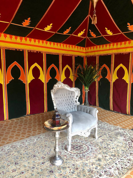 a chair sits in front of a colorful tent
