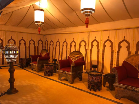 a row of chairs and tables under a tent