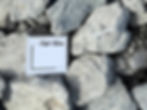 3 inch minus base with size scale showing large crushed rock pieces blended with fines for strong compaction.