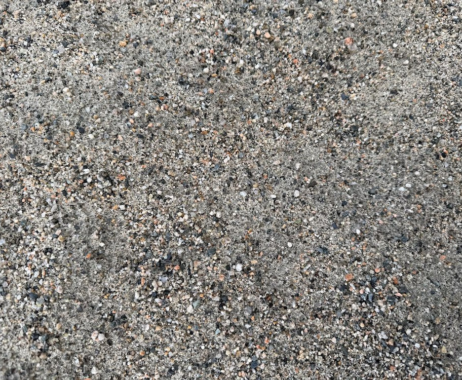 Close-up of Sechelt sand showing light-coloured, coarse sand with clean, uniform texture.