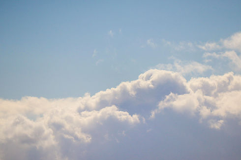 Image shows a picture of fluffy white clouds in a blue sky.