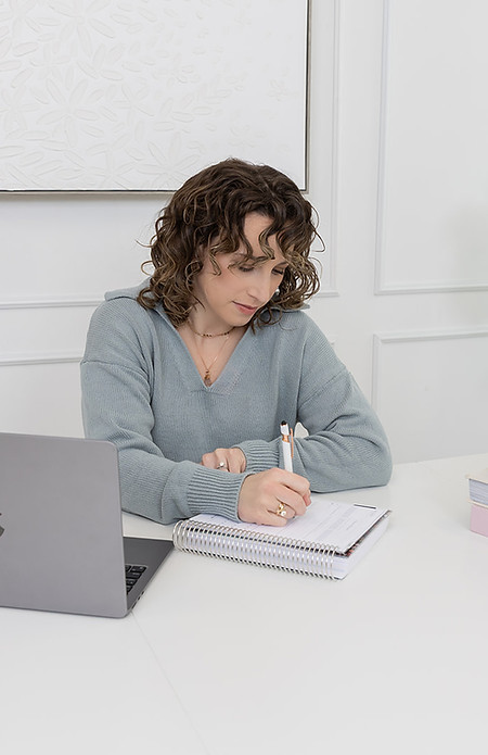 Brittany Shillingford sitting in a chair with computer writing on pad
