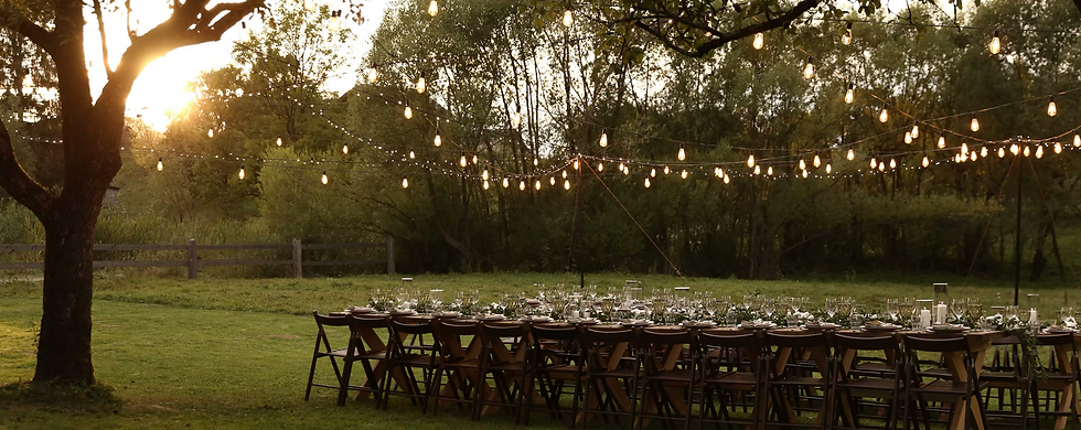 Rustic event rental setup for an elegant outdoor celebration on Long Island with farmhouse tables, warm lighting, and curated decor