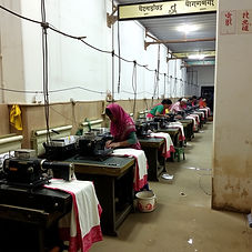 Factory line with workers using small machines like power handlooms
