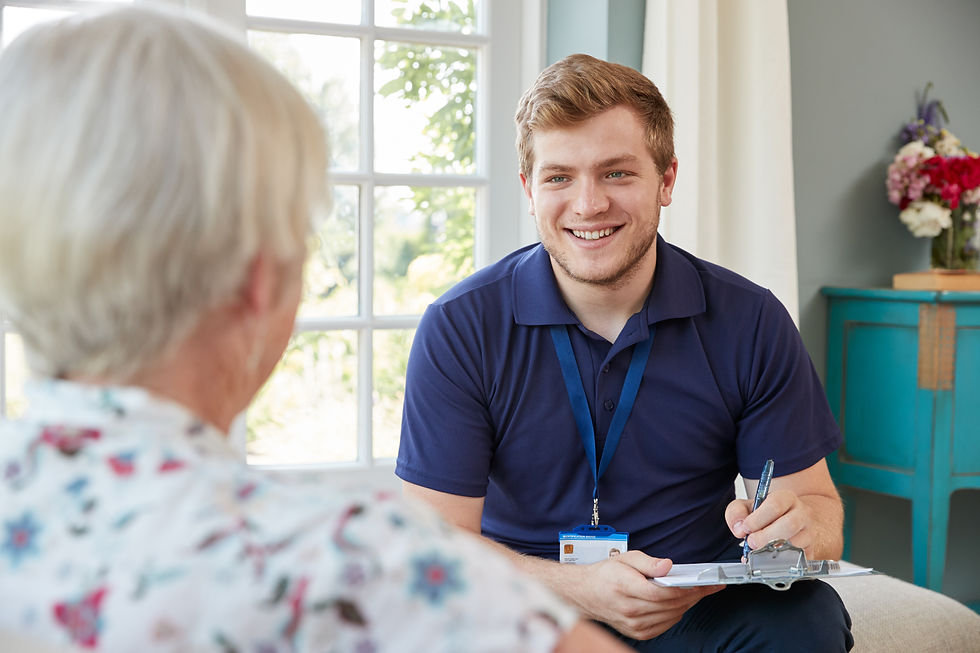Senior woman at home with male care worker making notes.jpg