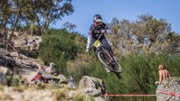 A mountain biker ijumping a downhill bike at a race