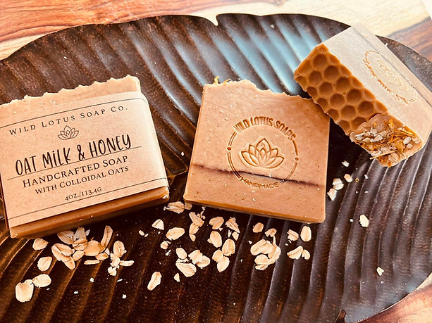 Three bars of soap on a metal platter surrounded by dried oats 