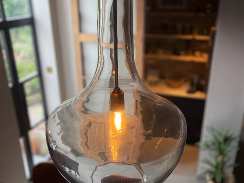 a clear glass pendant light with a light inside of it