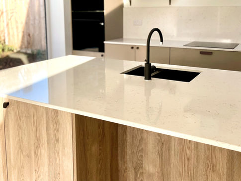 a kitchen with a black sink and a white counter top