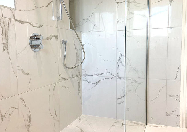 a bathroom with marble tiles and a walk in shower