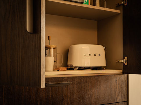 a smeg toaster sits on a shelf in a kitchen