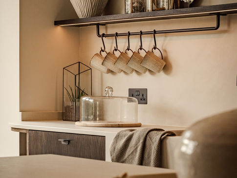 a kitchen with a shelf and mugs hanging from it