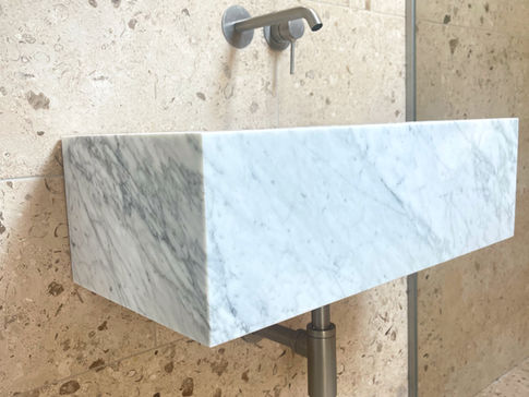 a bathroom sink made of marble and stainless steel