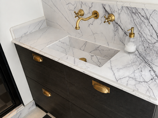 Modern bathroom with white vanity and black towel racks.