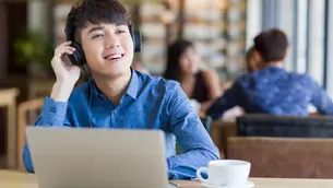 Young adult learner with headphones and a laptop practicing English listening and speaking online