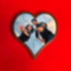 Heart-shaped wooden photo puzzle displayed on a bright red surface.