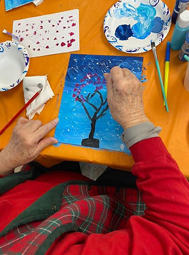 Elder participating in a painting activity in platte county at senior center.