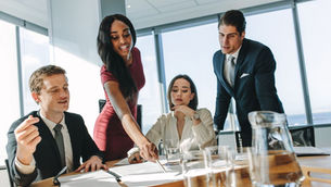 A young woman engages with her team utilizing the skills she obtained from a business English course.