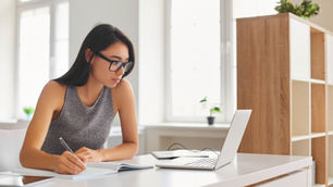 A young woman on her laptop engages on a business English online course.