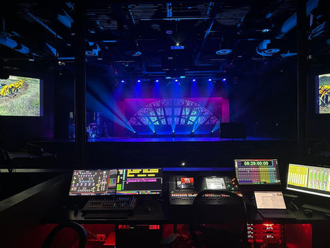 Stained glass rosette cover set center stage lit up with pink and blue. 