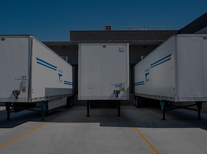 Imagem ilustrativa de três trailers brancos estacionados em uma garagem, relacionada ao projeto de naming estratégico da Bravolli, desenvolvido por Vanessa Schuh, fundadora da Plenomê.