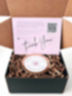 A candle in a box with a thank you card